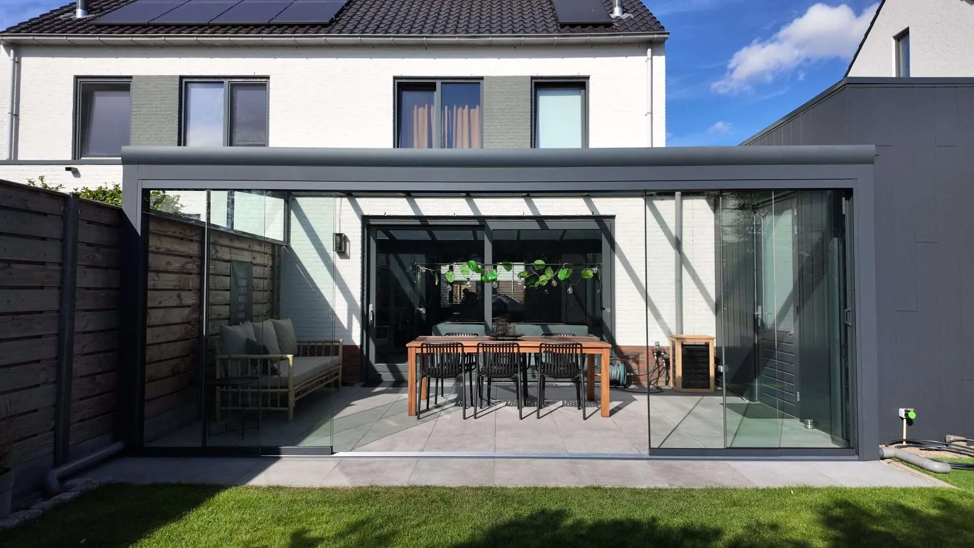 Maßgefertigte Aluminium-Glas-Veranda mit Schiebewänden an einem Einfamilienhaus